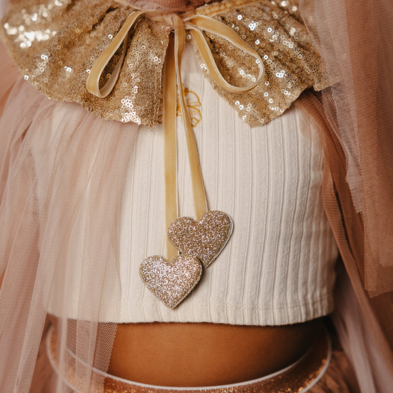 Criança de 7 anos vestida com um disfarce cor-de-rosa de unicórnio , com uma varinha mágica em forma de coração.