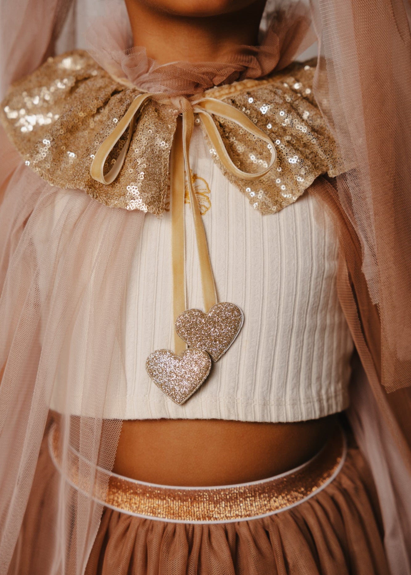 Criança de 7 anos vestida com um disfarce cor-de-rosa de unicórnio , com uma varinha mágica em forma de coração.